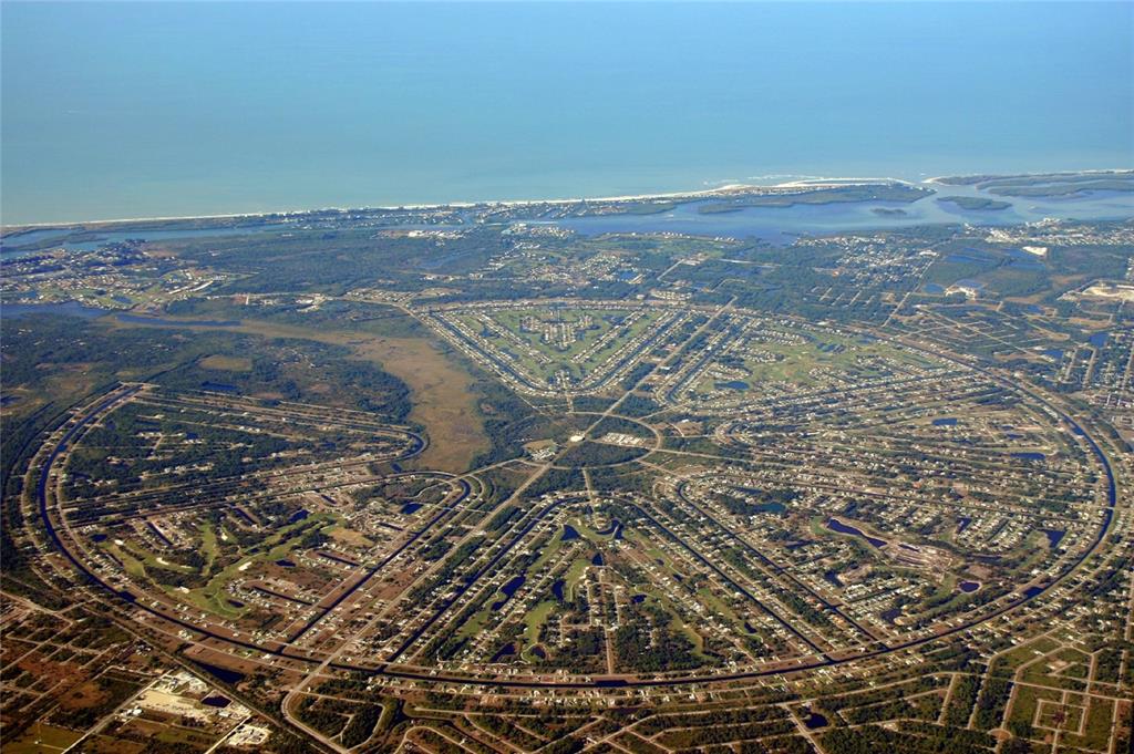 Aerial view of a circular residential development featuring radial streets and surrounding green spaces — 1162 BOUNDARY BOULEVARD, ROTONDA WEST, FL