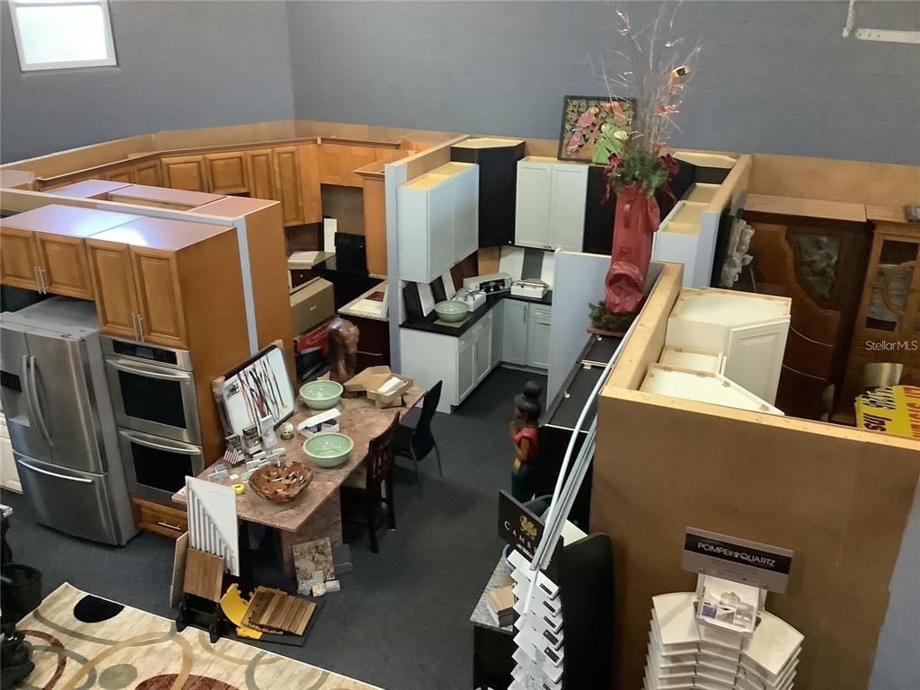 An elevated view of a kitchen showroom displaying various cabinet styles, countertops, and appliances — 10120 RIDGEWAY DRIVE, PORT RICHEY, FL