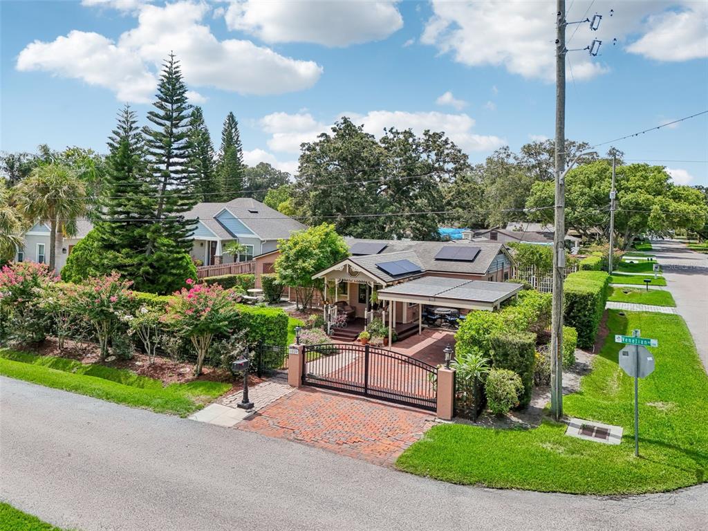 An aerial view shows a single-story house with solar panels, a gated driveway, and landscaping — 1020 VENETIAN AVENUE, ORLANDO, FL