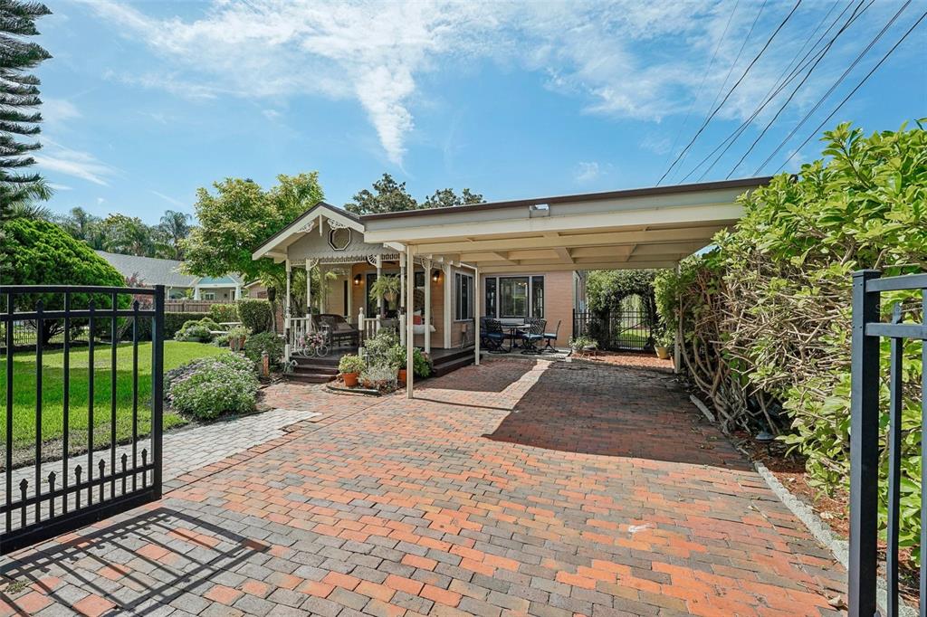 A brick driveway leads to a house with a front porch and an attached carport — 1020 VENETIAN AVENUE, ORLANDO, FL