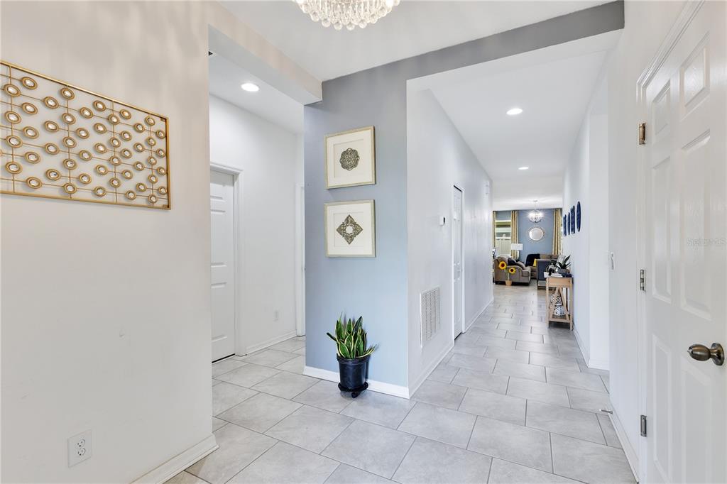A bright entryway with light tile flooring leads into a living area with blue accents — 3920 CABO ROJO DRIVE, ST CLOUD, FL