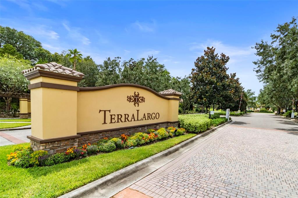 A tan stucco monument sign for the TerraLargo community stands beside a paved entrance road — 4030 SOLAMOR STREET, LAKELAND, FL