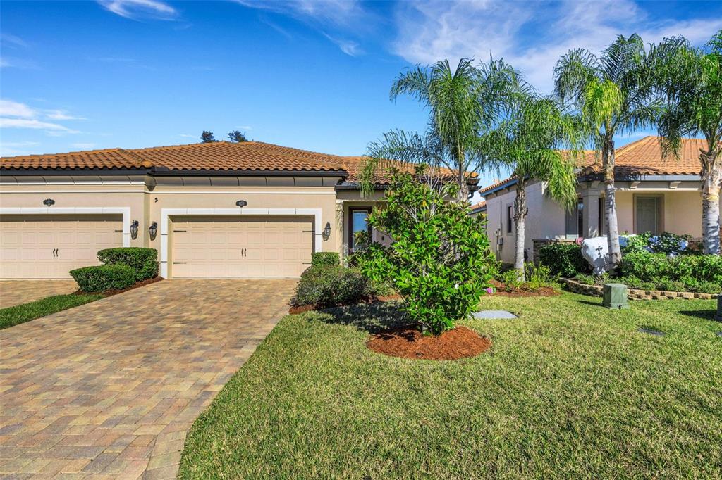 A single-story house with a tiled roof, two-car garage, and a paved driveway — 4030 SOLAMOR STREET, LAKELAND, FL