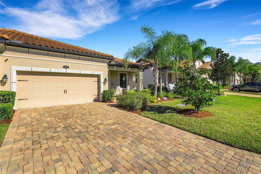 A single-story house with a paved driveway, a two-car garage, and palm trees — 4030 SOLAMOR STREET, LAKELAND, FL
