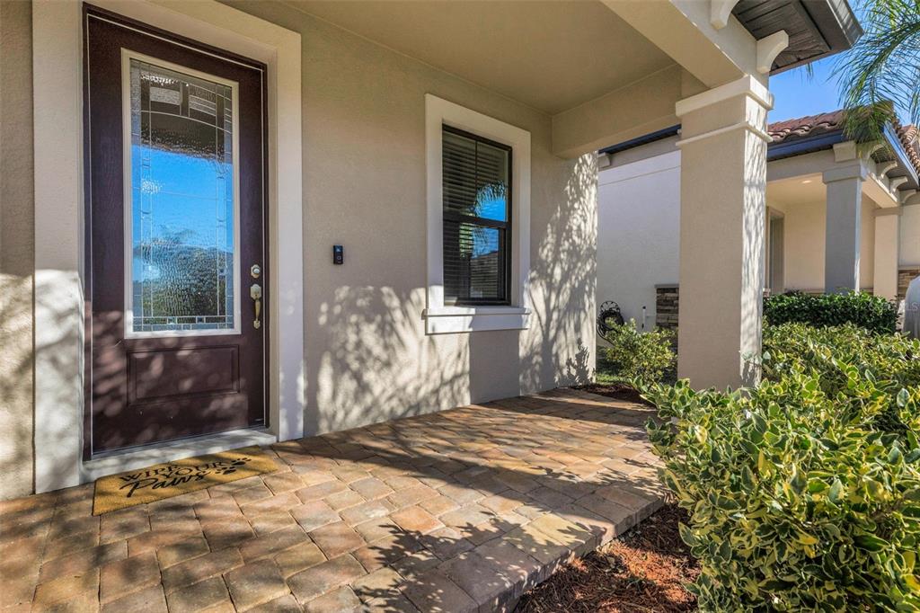 A paved front porch features a dark brown front door and a small window — 4030 SOLAMOR STREET, LAKELAND, FL