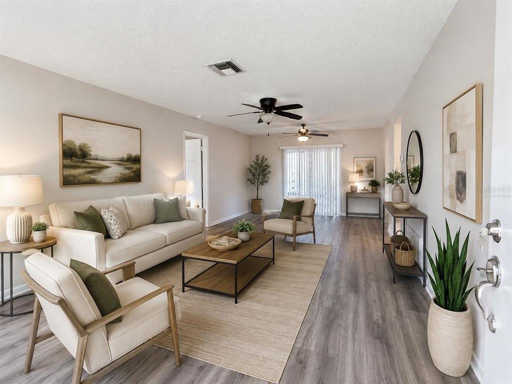 A living room features light-colored furniture, a wooden coffee table, and wood-look flooring — 9129 SEWELL LANE, SPRING HILL, FL