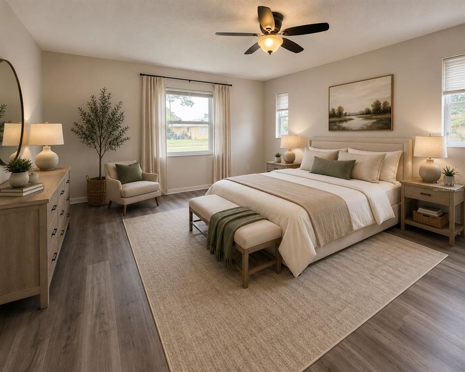 A virtually staged bedroom features a bed, dresser, armchair, and wood-look flooring — 9129 SEWELL LANE, SPRING HILL, FL