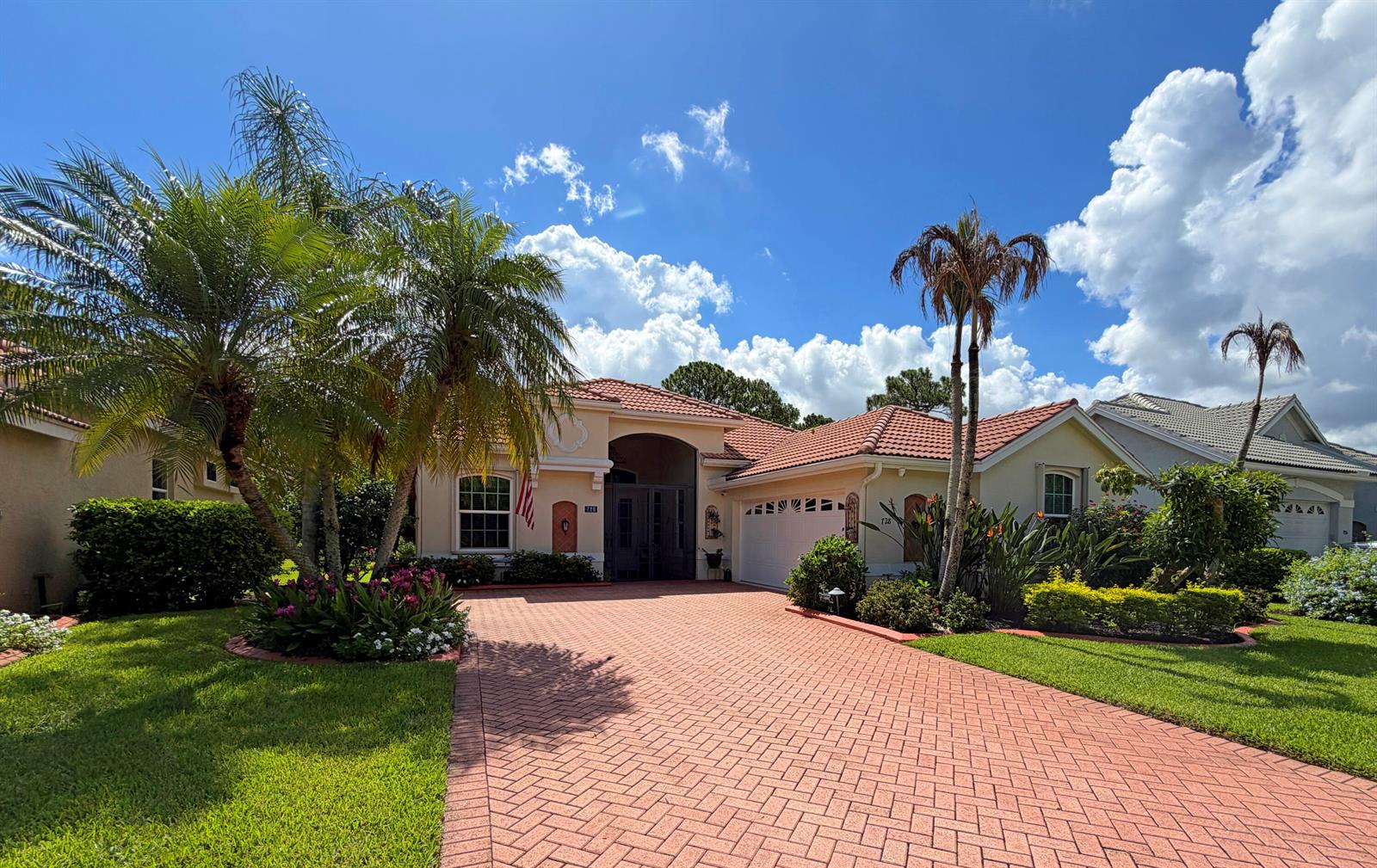 A single-story house with a red-tiled roof and a brick-paved driveway under a blue sky — 728 SW Lake Charles Circle, Port St. Lucie FL 34986, PORT ST. LUCIE, FL