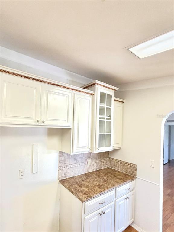 A kitchen features white cabinets with rope molding, a glass-front display cabinet, and brown countertops — 3217 NW 64TH STREET, COCONUT CREEK, FL