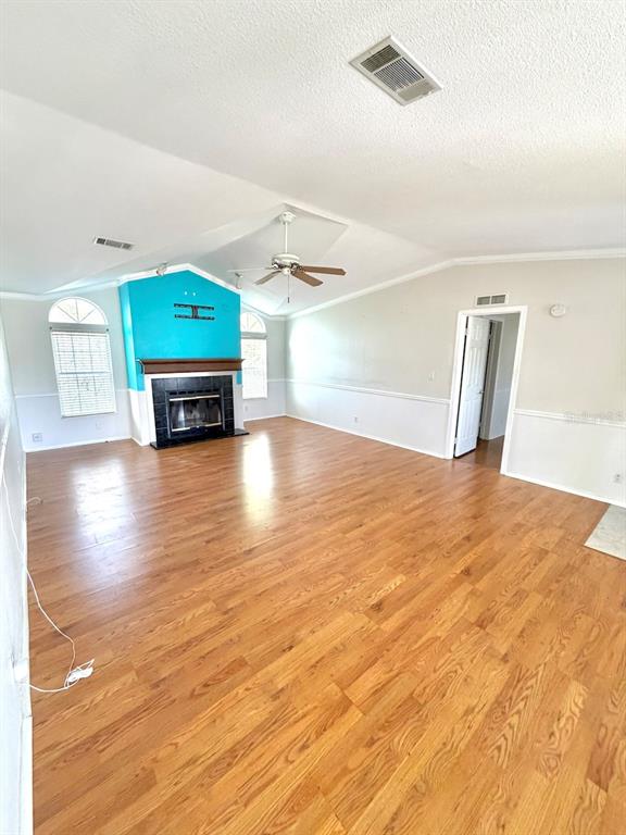 A living room features wood-look flooring, a vaulted ceiling, and a bright blue fireplace wall — 3217 NW 64TH STREET, COCONUT CREEK, FL