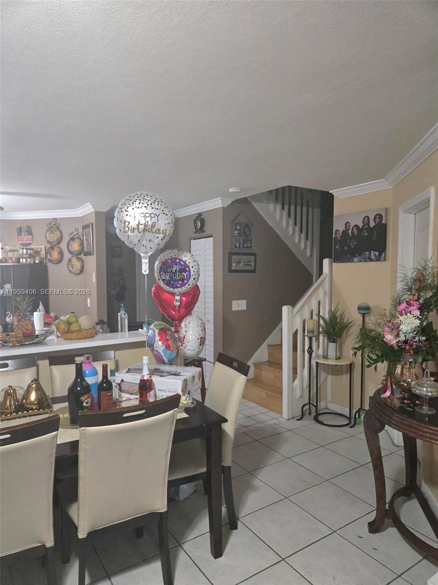 A dining area features a table with chairs, birthday balloons, and a staircase nearby — 4925 W Lakes Dr, Deerfield Beach FL 33442, DEERFIELD BEACH, FL