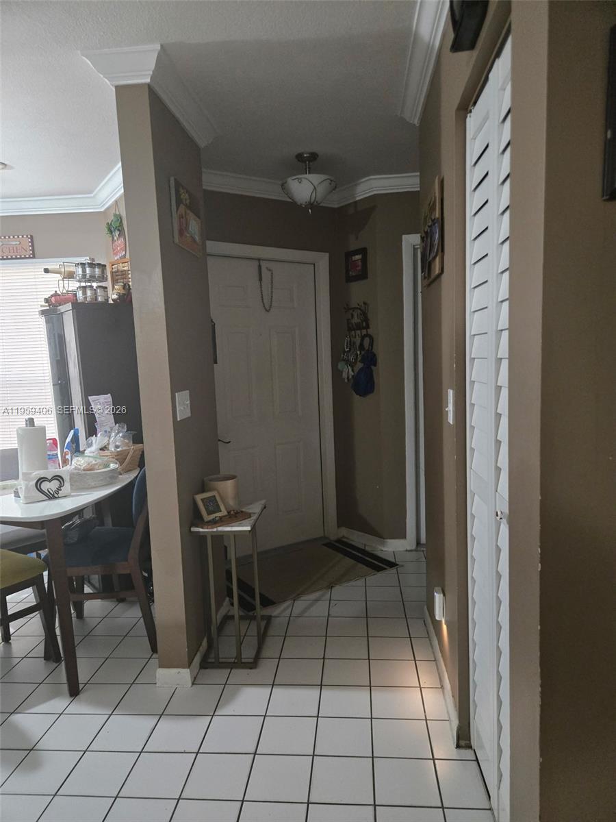 A tiled entryway leads to a white front door with a small side table — 4925 W Lakes Dr, Deerfield Beach FL 33442, DEERFIELD BEACH, FL