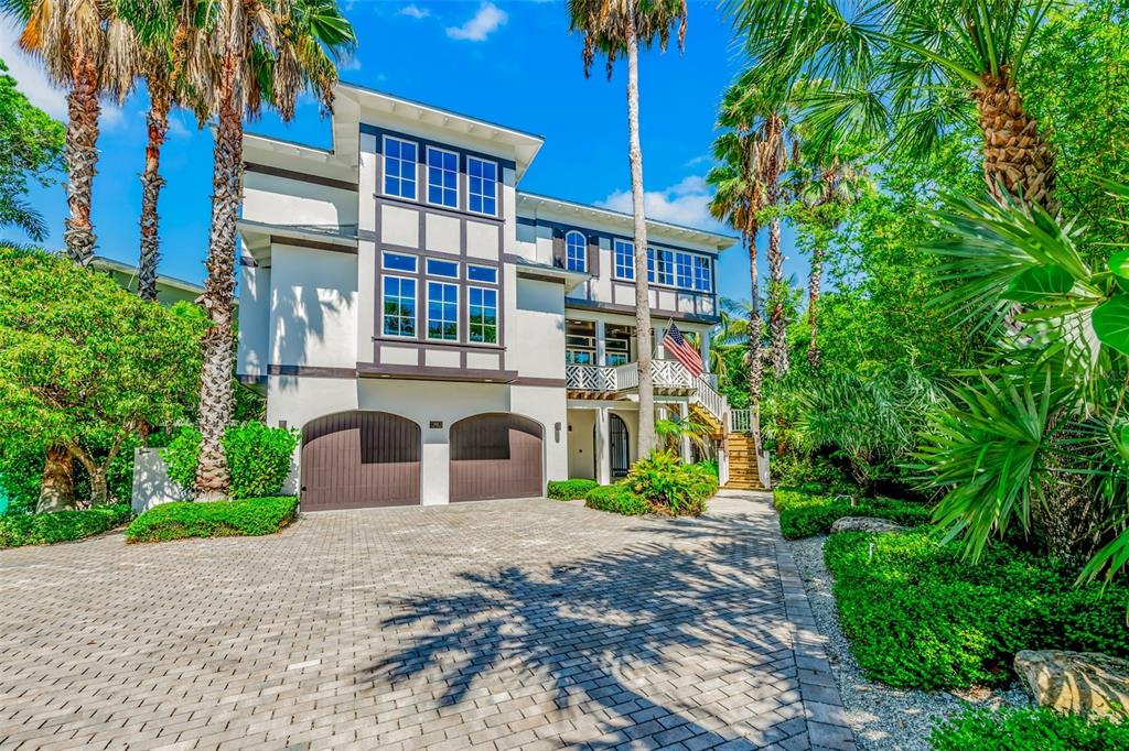 A three-story house with a two-car garage and a paved driveway surrounded by palm trees — 103 PARK AVENUE, ANNA MARIA, FL