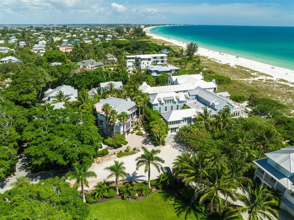 An aerial view of a large coastal estate surrounded by trees near a sandy beach — 103 PARK AVENUE, ANNA MARIA, FL