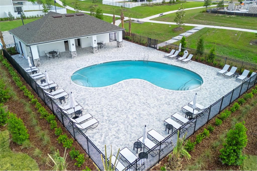 An aerial view shows a kidney-shaped swimming pool surrounded by lounge chairs and a clubhouse — 4507 LAUREL SITE LOOP, APOPKA, FL