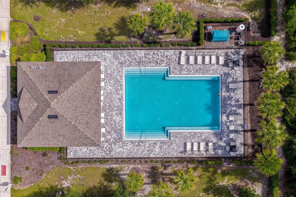 An aerial view shows a rectangular swimming pool with a surrounding patio and adjacent building — 1514 PLAYWRIGHT DRIVE, DELAND, FL
