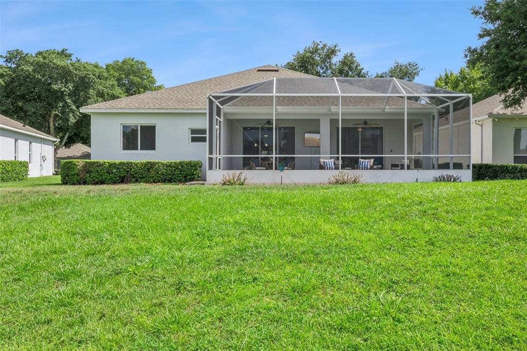 An aerial view shows several houses with screened-in lanais situated along a grassy golf course — 2284 ADDISON AVENUE, CLERMONT, FL
