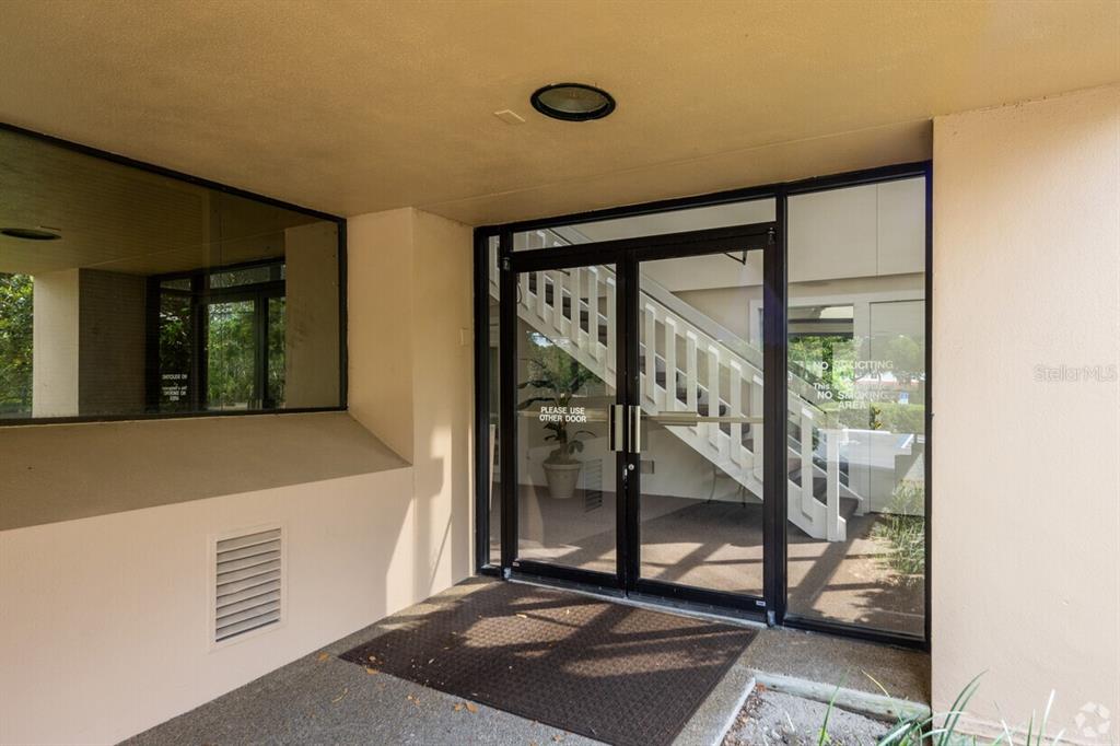 A glass double door entrance leads to an interior staircase under a covered walkway — 901 DOUGLAS AVENUE UNIT 239, ALTAMONTE SPRINGS, FL