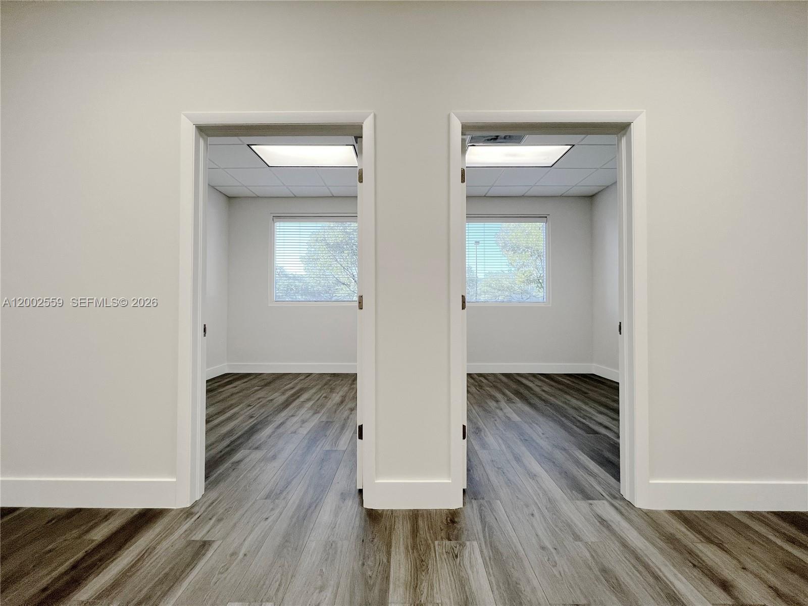 Two identical empty office rooms feature grey wood-look flooring and white walls — 7791 NW 46th St # 104, Doral FL 33166, DORAL, FL