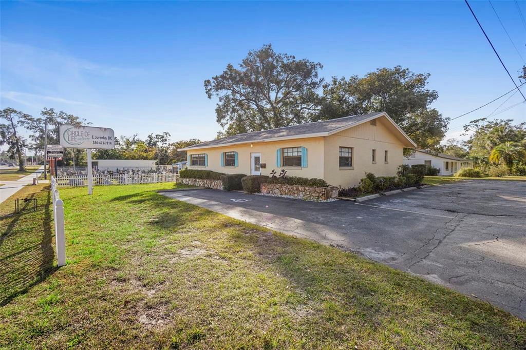 A single-story commercial building with a tan exterior, stone accents, and a paved parking lot — 1995 N VOLUSIA AVENUE, ORANGE CITY, FL