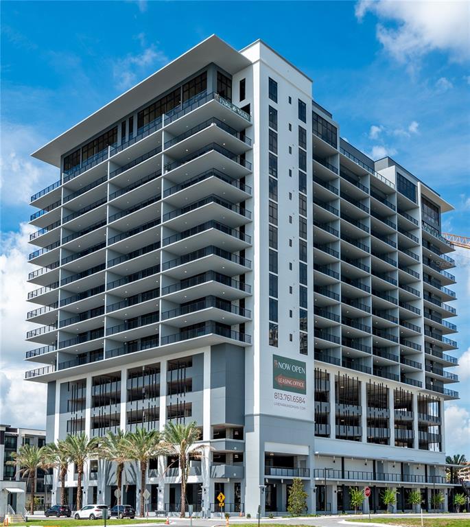A modern, multi-story apartment building with balconies and a ground-level parking garage — 221 MAIN STREET N UNIT A3-1506, ST PETERSBURG, FL