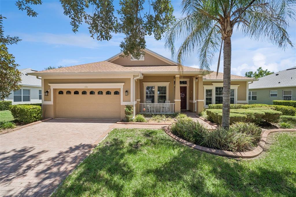 A single-story house with a tan exterior, a two-car garage, and a palm tree — 220 BAYOU BEND ROAD, GROVELAND, FL