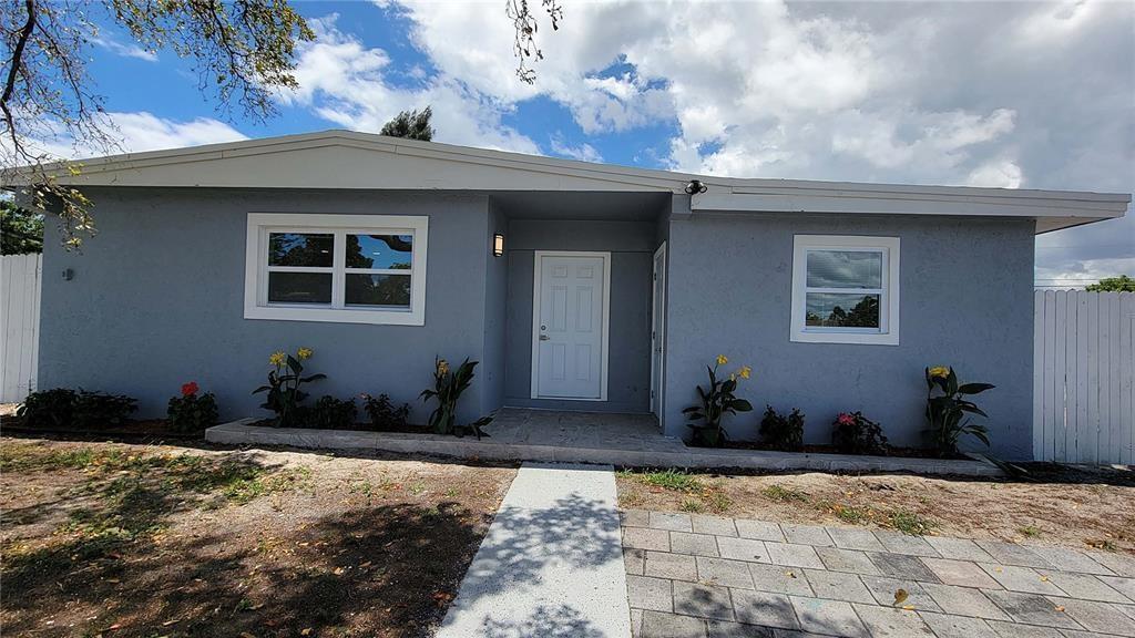 A gray, single-story house with a white front door and a paved walkway — 266 NE 42nd Street, Deerfield Beach FL 33064, DEERFIELD BEACH, FL