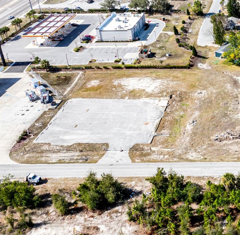 An aerial view shows a vacant concrete building foundation surrounded by undeveloped land and parking — 4035 THYS ROAD, NEW PORT RICHEY, FL