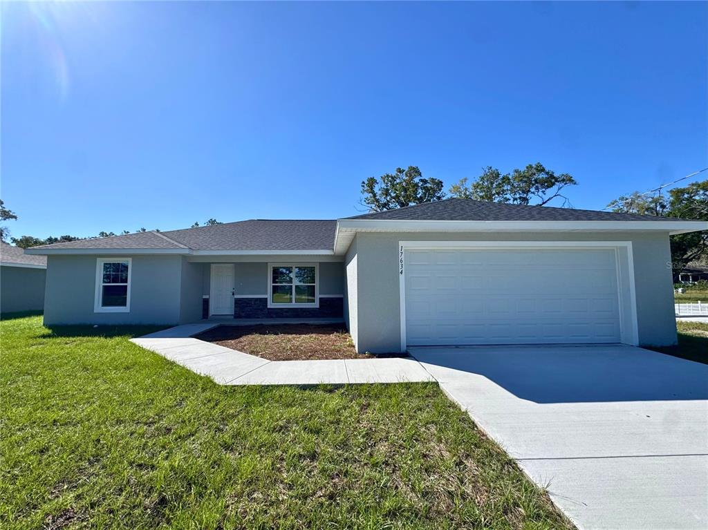 A single-story house with a gray exterior, a two-car garage, and a concrete walkway — 5982 N MATHESON DRIVE, CITRUS SPRINGS, FL