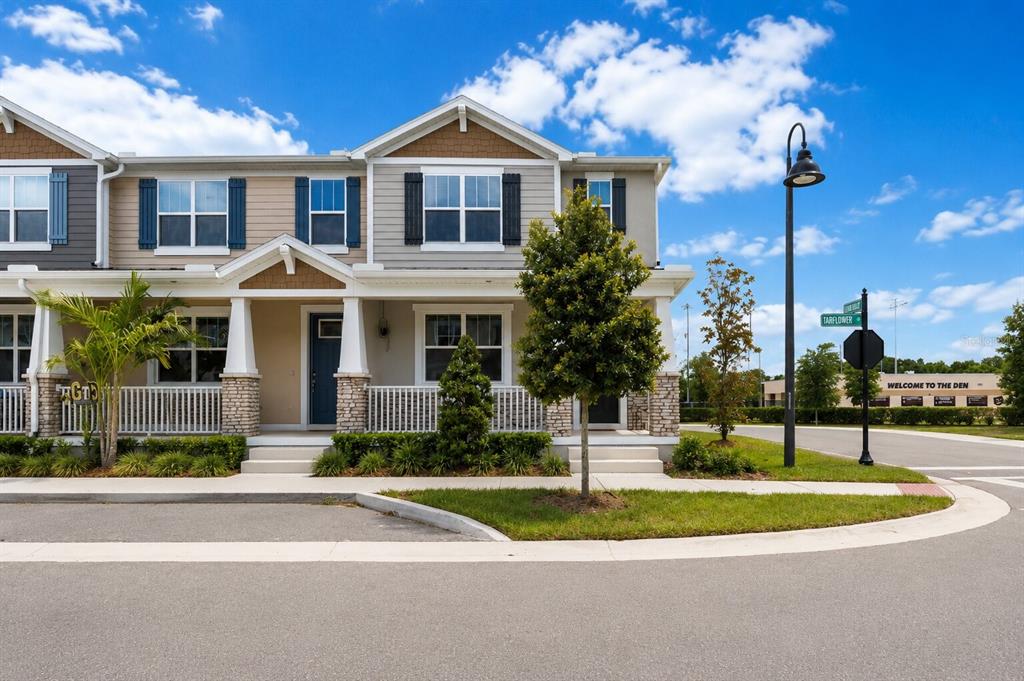 A two-story townhouse with light-colored siding, stone accents, and a front porch — 1326 TARFLOWER DRIVE, WINTER SPRINGS, FL