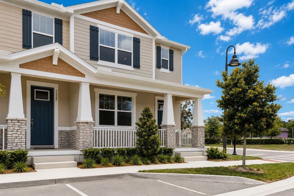 A two-story townhouse exterior with a blue front door, stone accents, and a covered porch — 1326 TARFLOWER DRIVE, WINTER SPRINGS, FL