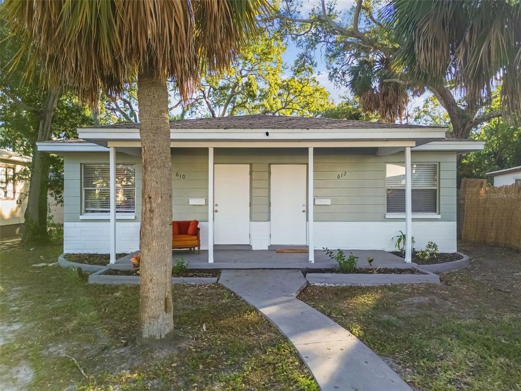 A single-story duplex with light green siding, white trim, and a shared front porch — 610 16TH AVENUE S, ST PETERSBURG, FL