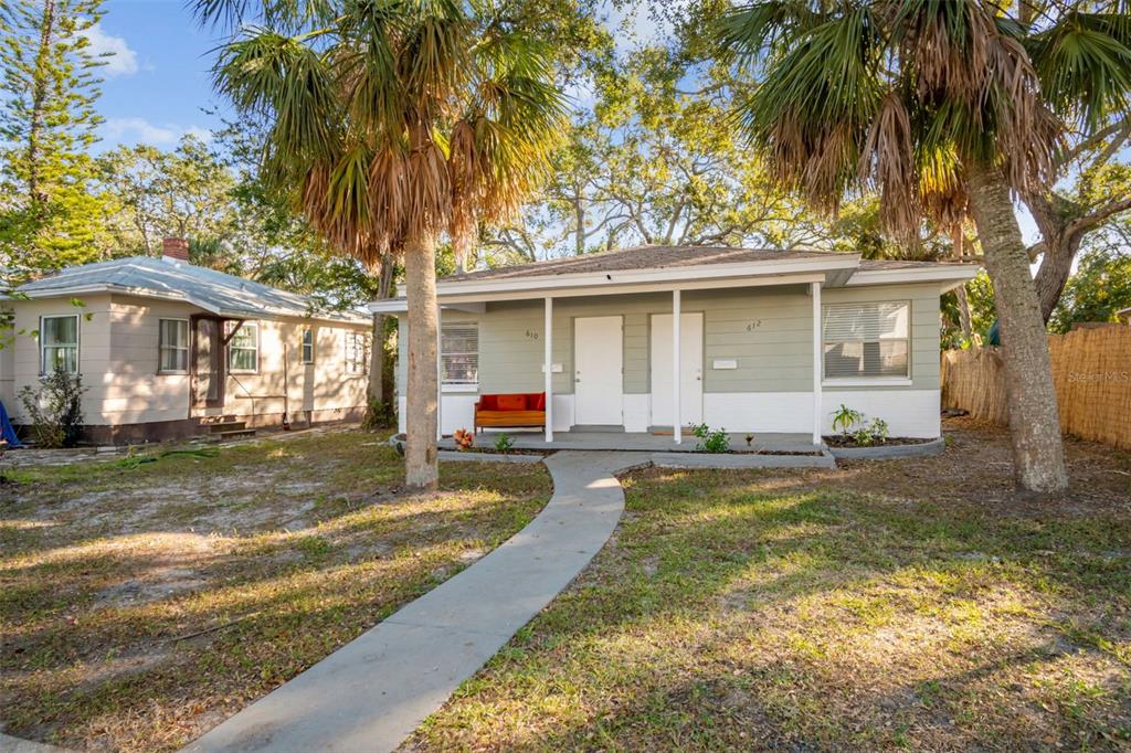 A single-story duplex with a concrete walkway, covered front porch, and palm trees — 610 16TH AVENUE S, ST PETERSBURG, FL