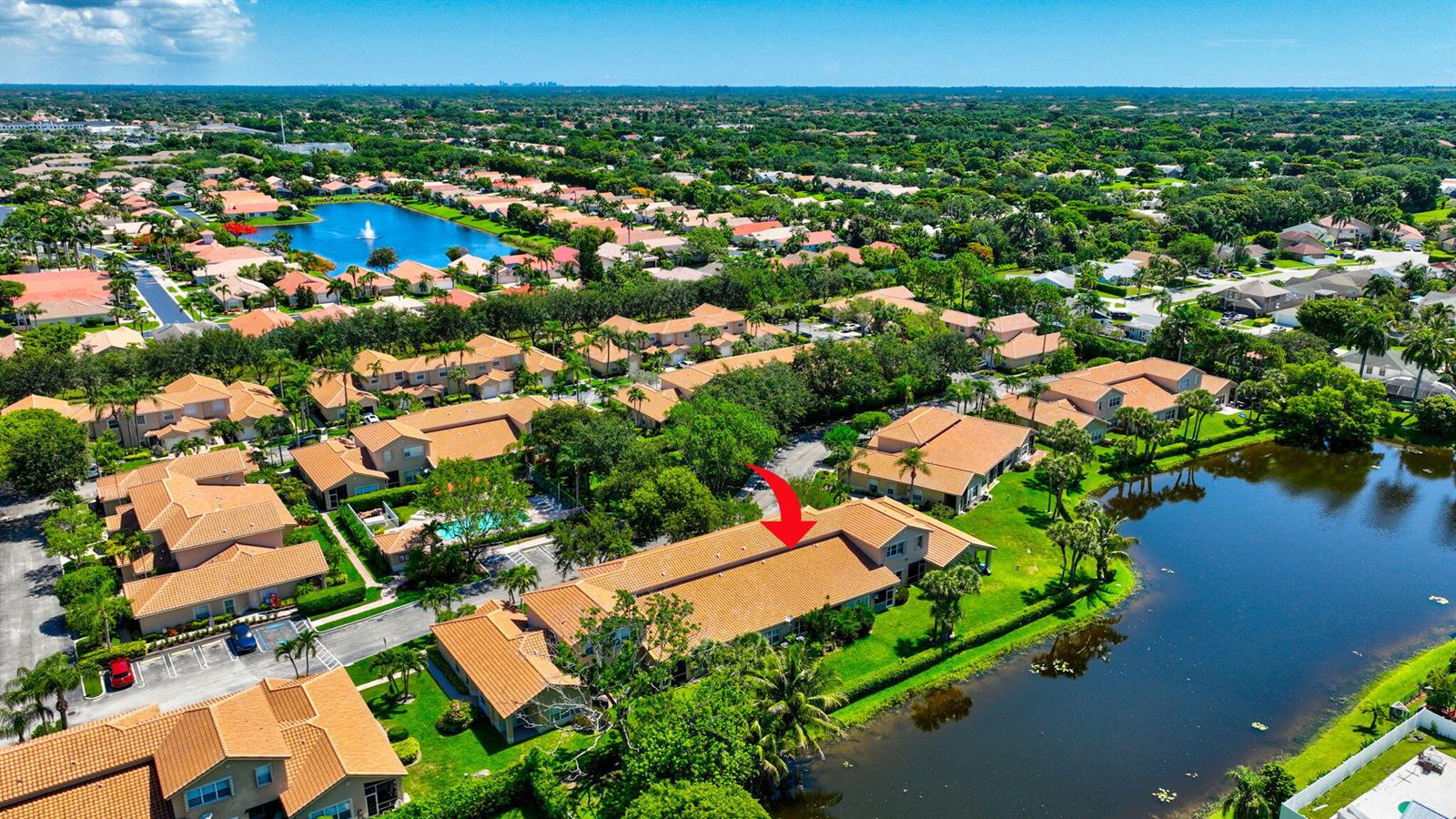 An aerial view shows a residential building with a tiled roof next to a lake — 6374 Park Lake Circle, Boynton Beach FL 33437, BOYNTON BEACH, FL
