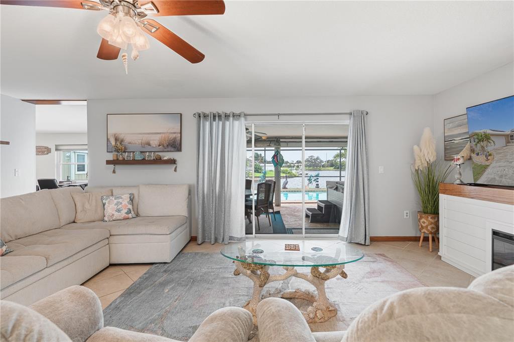 A living room features a sectional sofa, glass coffee table, and sliding doors to a pool — 2284 BROAD RANCH DRIVE, PORT CHARLOTTE, FL