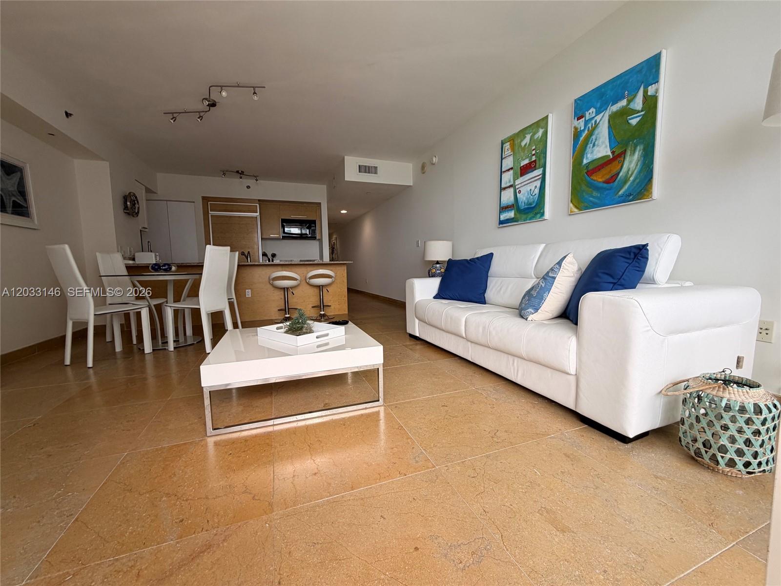 A living room features a white sofa, a coffee table, and an open kitchen area — 1830 S Ocean Dr # 2412, Hallandale Beach FL 33009, HALLANDALE BEACH, FL