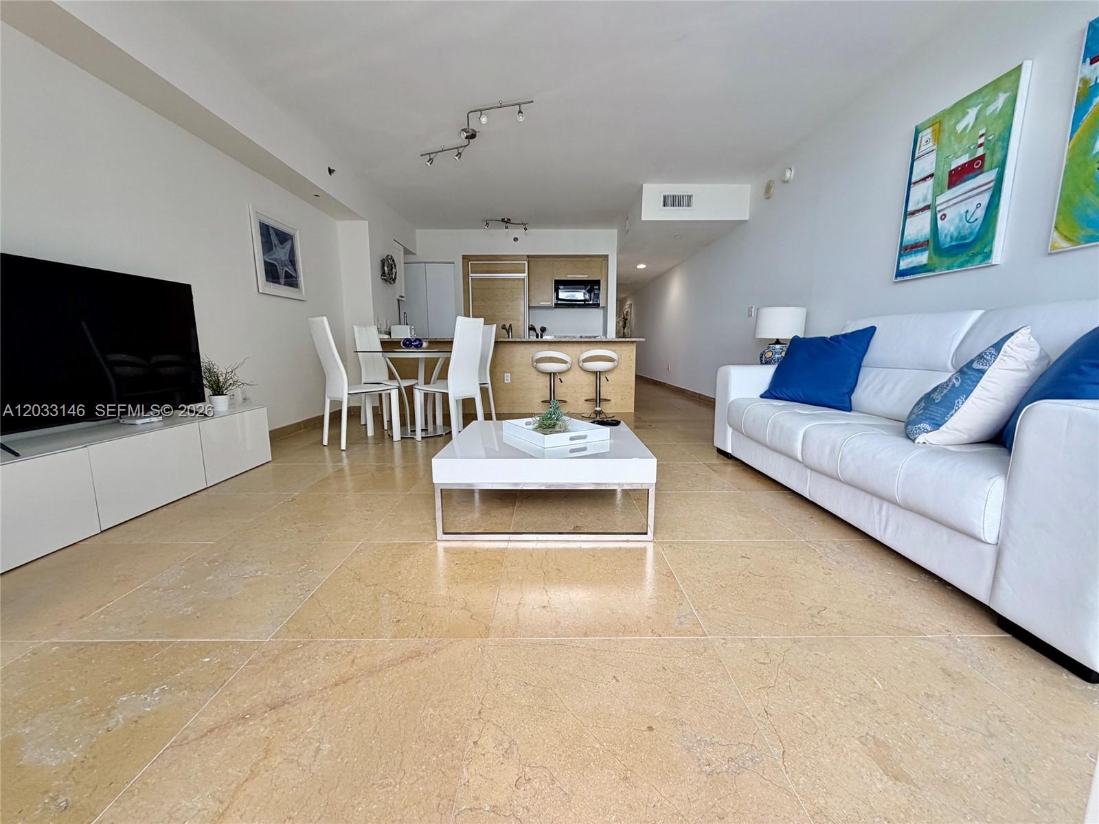 A living room features a white sofa, a coffee table, and tile flooring — 1830 S Ocean Dr # 2412, Hallandale Beach FL 33009, HALLANDALE BEACH, FL