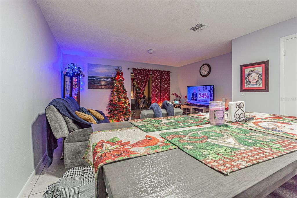 A living room features a Christmas tree, a television, and a dining table with placemats — 4010 OAK LIMB COURT, TAMPA, FL
