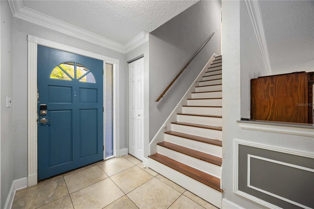 An entryway features a blue front door, tile flooring, and a staircase with wooden treads — 1035 OLD POLK CITY ROAD, LAKELAND, FL