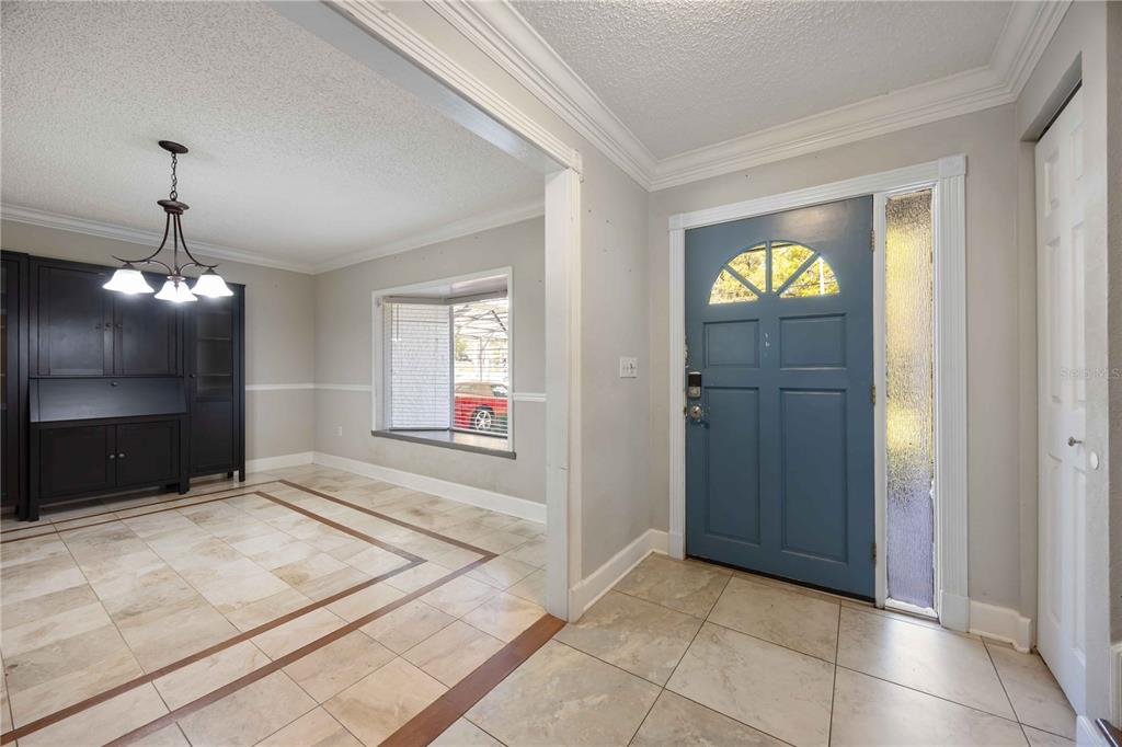 An entryway with tiled floors leads into a dining area featuring a dark hutch — 1035 OLD POLK CITY ROAD, LAKELAND, FL