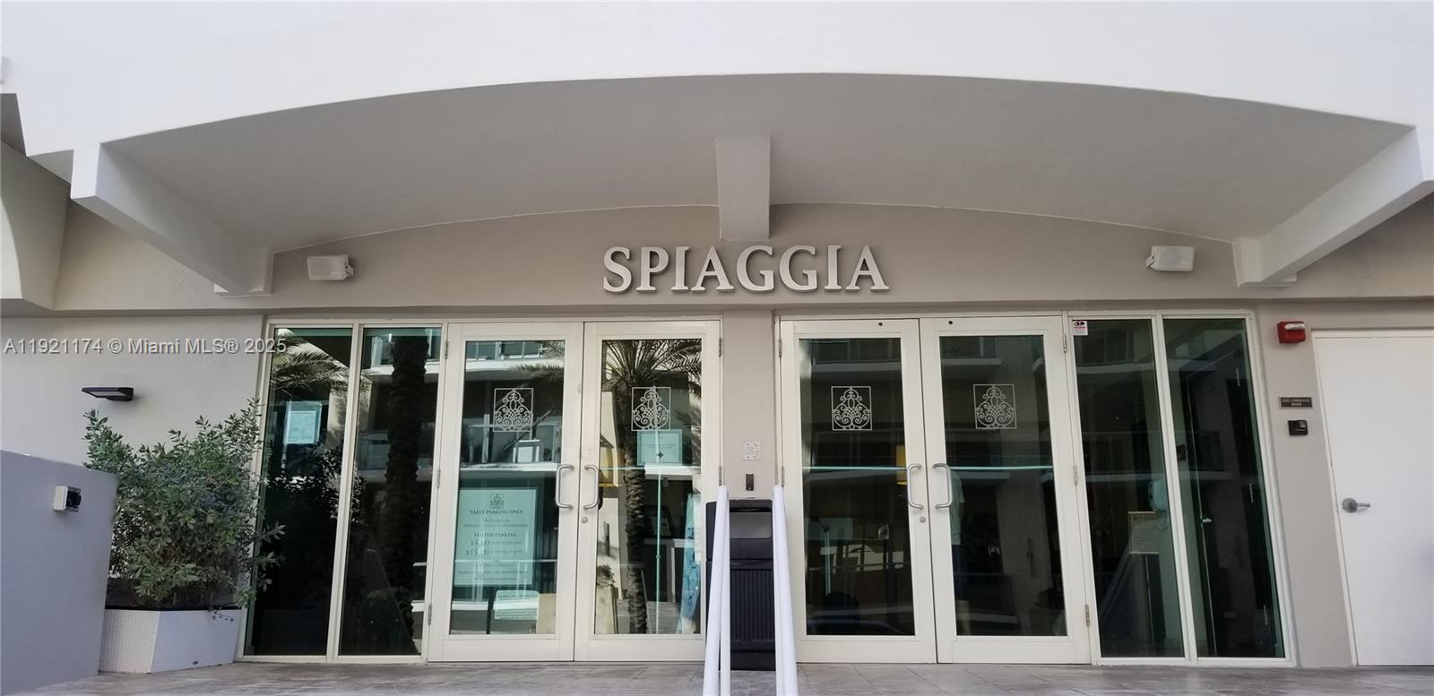 The exterior entrance of the Spiaggia building features glass double doors and signage — 9499 Collins Avenue # 02, Surfside FL 33154, SURFSIDE, FL