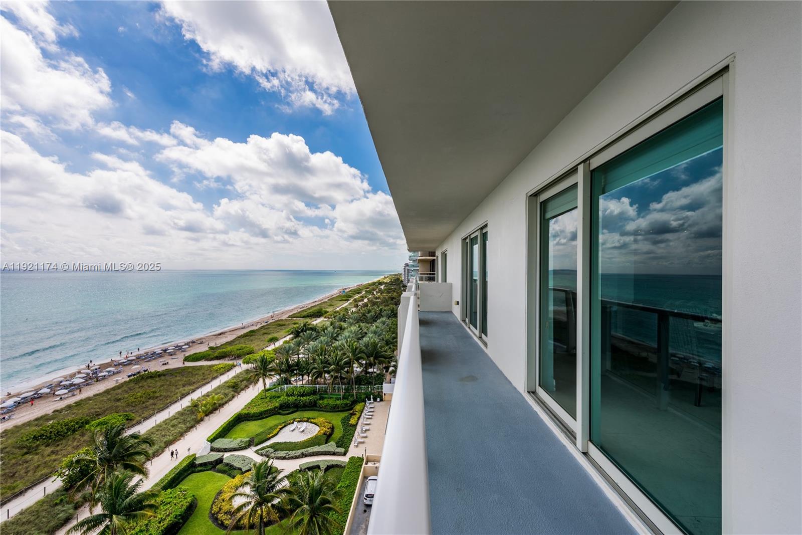 A high-rise balcony overlooks a beach, palm trees, and the ocean — 9499 Collins Avenue # 02, Surfside FL 33154, SURFSIDE, FL
