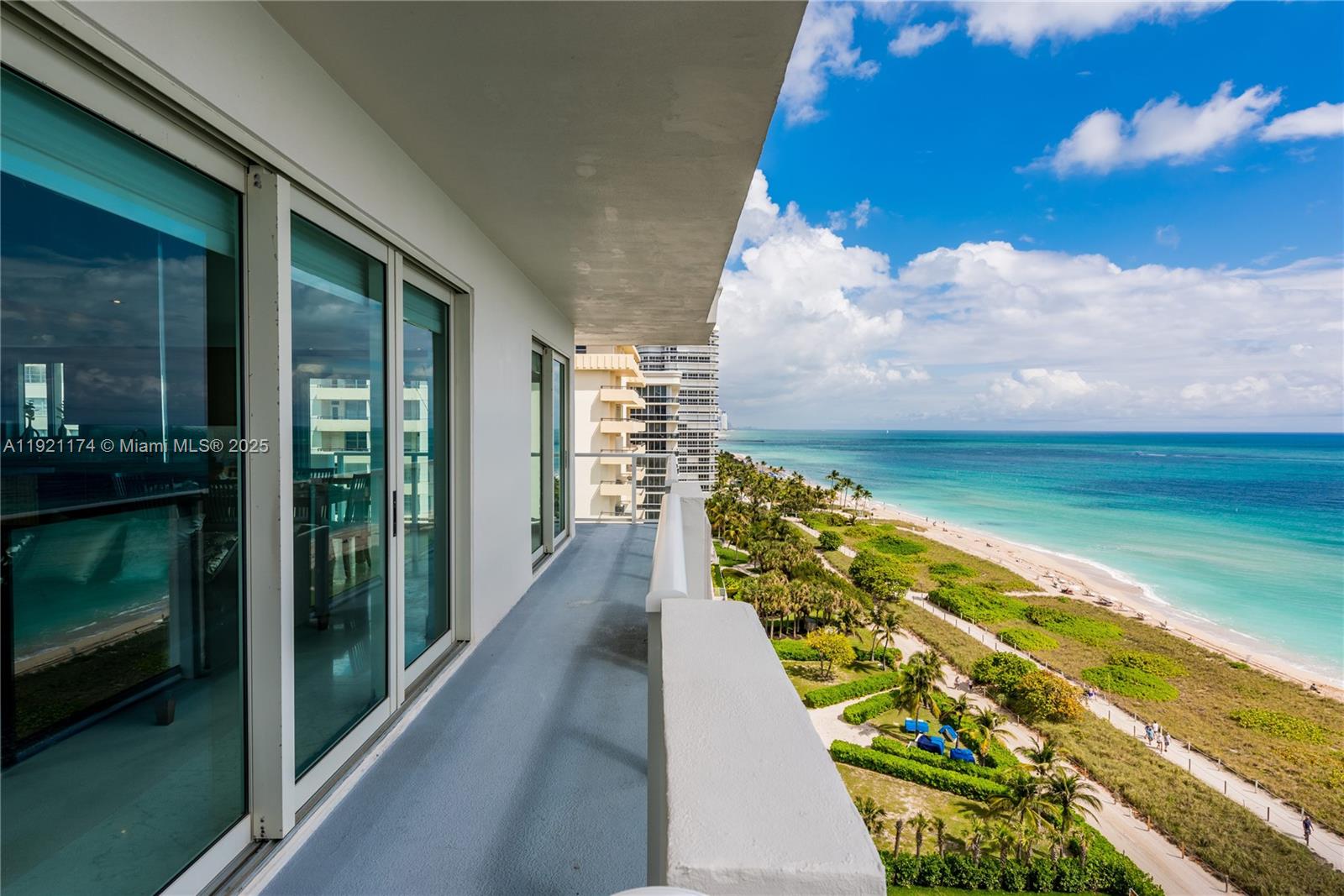 A balcony with a concrete floor overlooks a sandy beach and the ocean — 9499 Collins Avenue # 02, Surfside FL 33154, SURFSIDE, FL