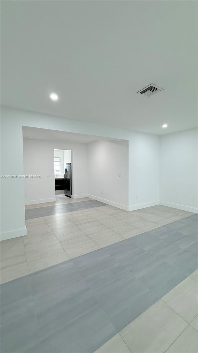 This interior view shows an open-plan room with light-colored tile flooring and white walls — 2021 Meridian Ave # 6, Miami Beach FL 33139, MIAMI BEACH, FL