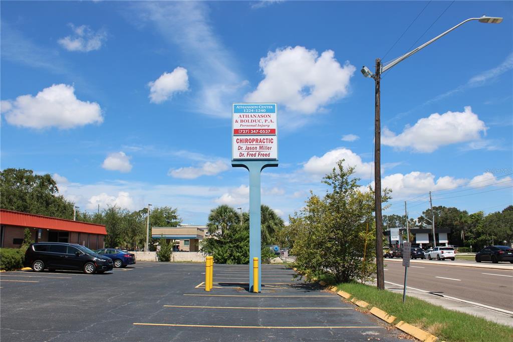 A parking lot sits in front of a tall business sign under a blue sky — 1224 66TH STREET N UNIT 1234,1238,1240, ST PETERSBURG, FL