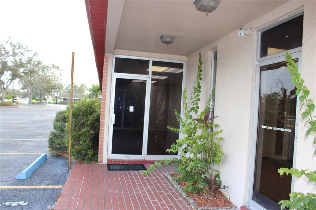 An exterior view of a building entrance with two glass doors and a brick walkway — 1224 66TH STREET N UNIT 1234,1238,1240, ST PETERSBURG, FL
