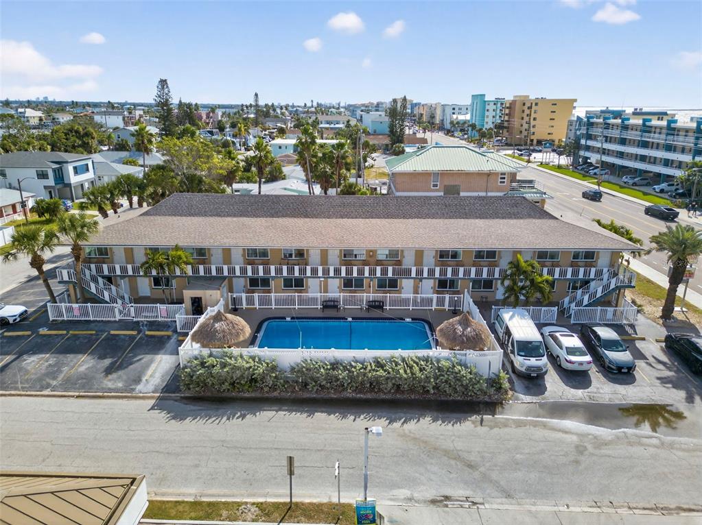 An aerial view shows a two-story motel with a swimming pool and parking lot — 14251 GULF BOULEVARD UNIT 5, MADEIRA BEACH, FL