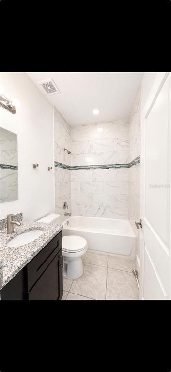 A bathroom features a granite vanity, a white toilet, and a tub-shower with marble-look tile — 9130 N MENDOZA WAY, CITRUS SPRINGS, FL