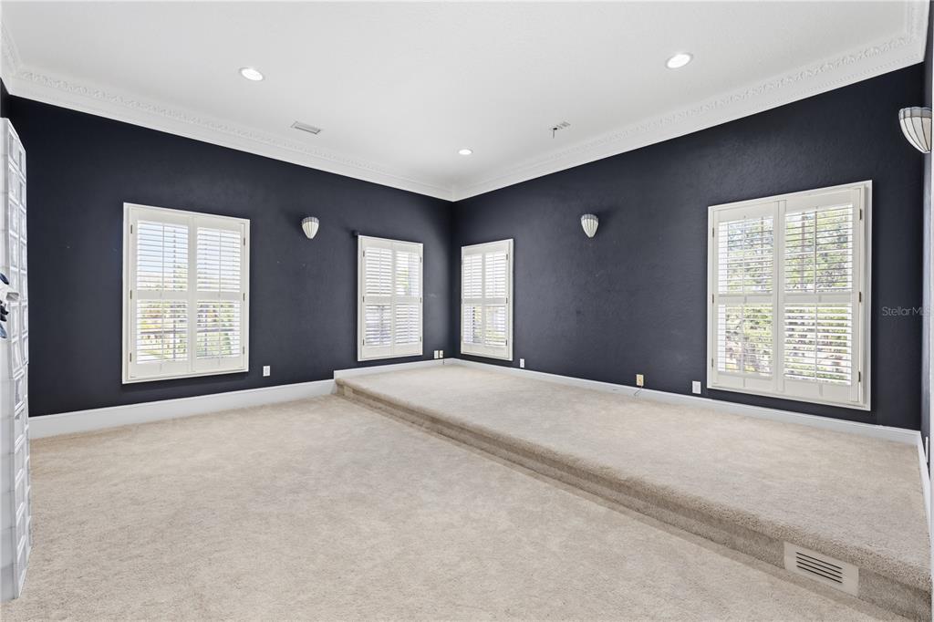 A spacious living room features high ceilings, marble-look tile floors, and a white fireplace — 3017 OAKMONT DRIVE, CLEARWATER, FL