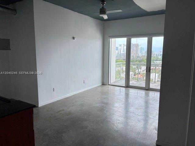 An empty room with concrete floors, a dark ceiling, and a glass door to a balcony — 10 SW South River Dr # 1109, Miami FL 33130, MIAMI, FL